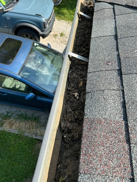 Heavy gutter buildup before BrightEdge cleaning